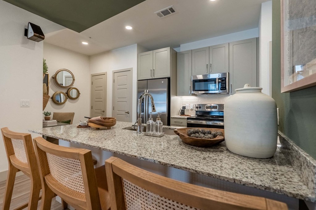 a kitchen with a granite counter top with a large vase on it