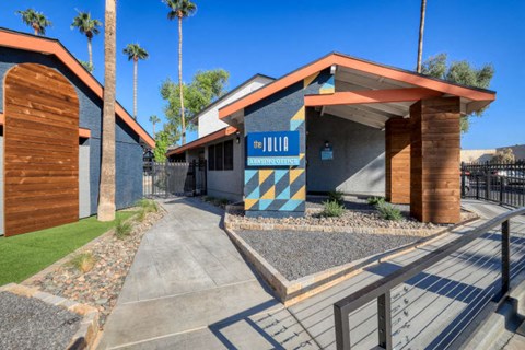 a building with a blue and yellow sign in front of it at The Julia, Mesa, AZ