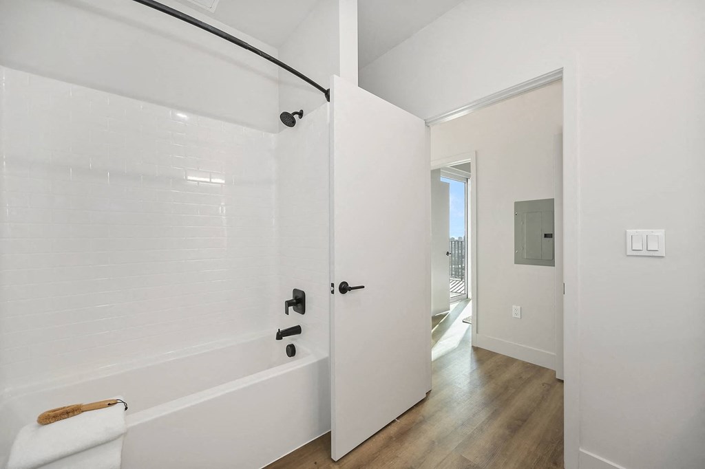 a white bathroom with a shower and a door