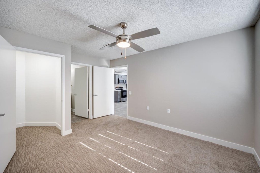 an empty living room with a ceiling fan