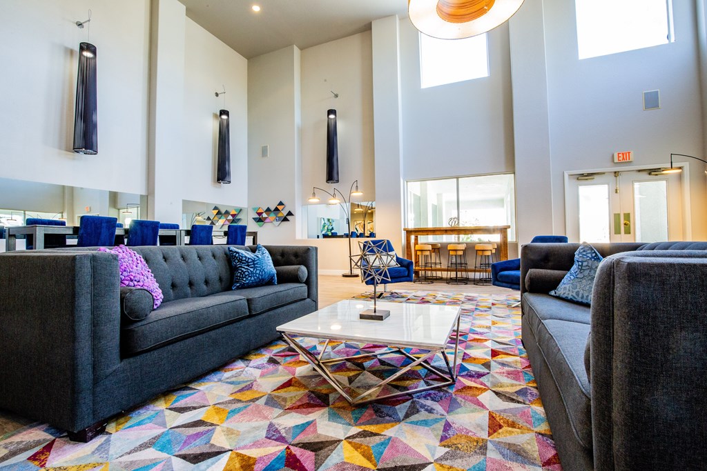 A club house seating area with couches and a colorful rug.