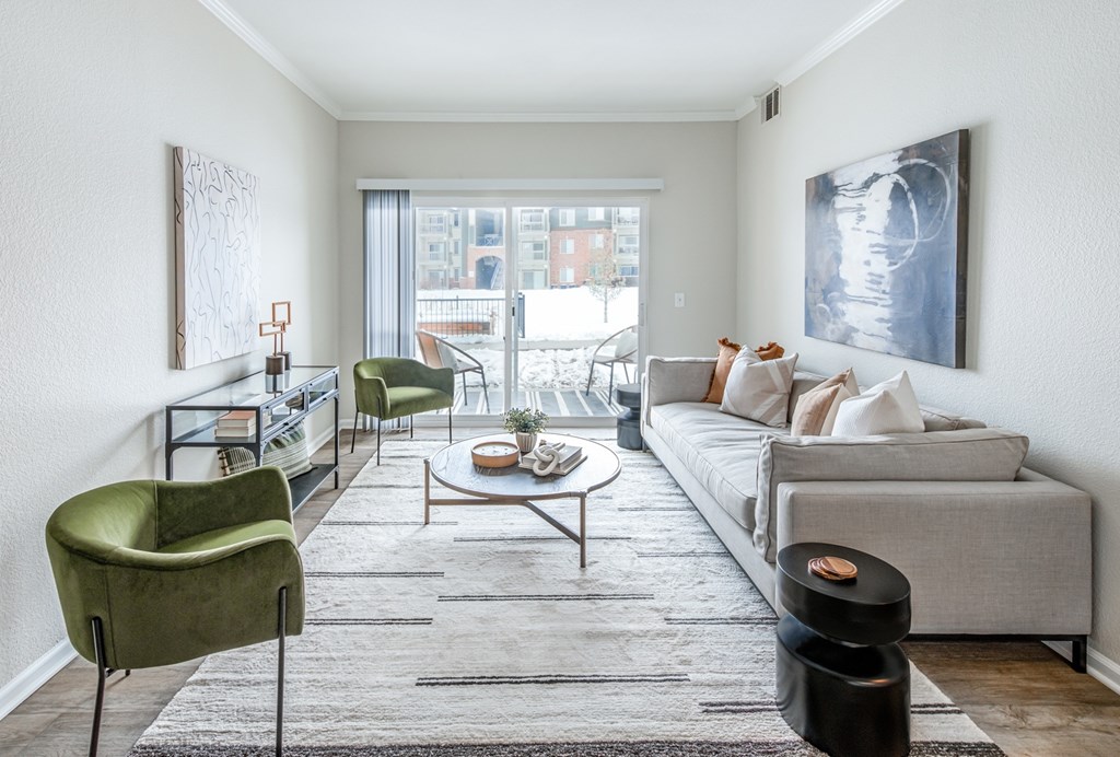 A living room with a grey couch, a green chair, and a coffee table.