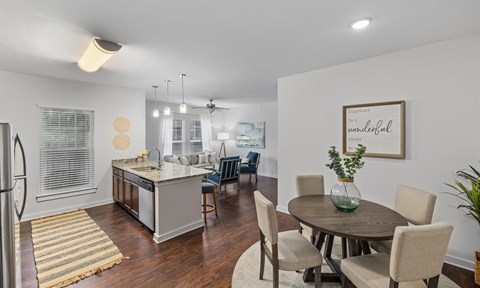 A kitchen with a dining table and chairs.