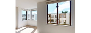 a living room with large windows and a view of a building