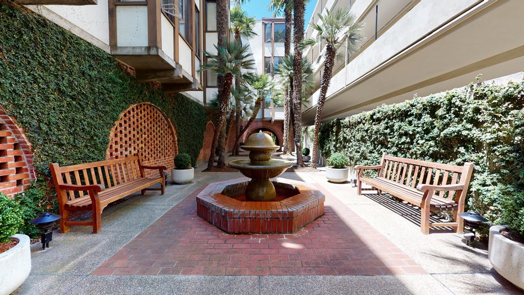 a courtyard with a fountain and benches