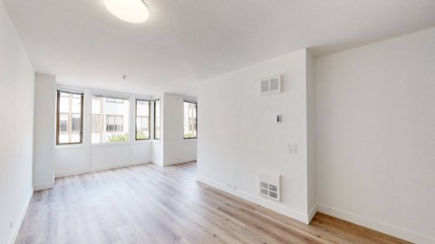 a bedroom with hardwood floors and white walls
