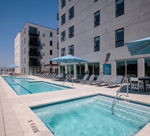 A swimming pool with a waterfall feature in the middle of it.
