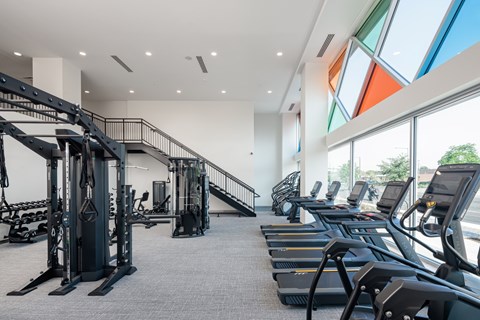 A gym with treadmills and a staircase.