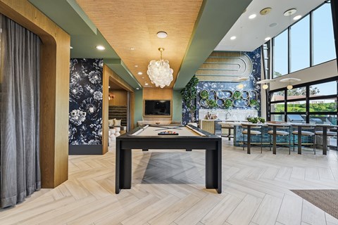A modern dining room with a pool table and a large window.