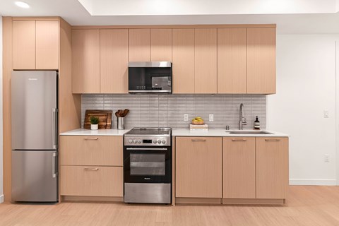 A kitchen with wooden cabinets and stainless steel appliances.