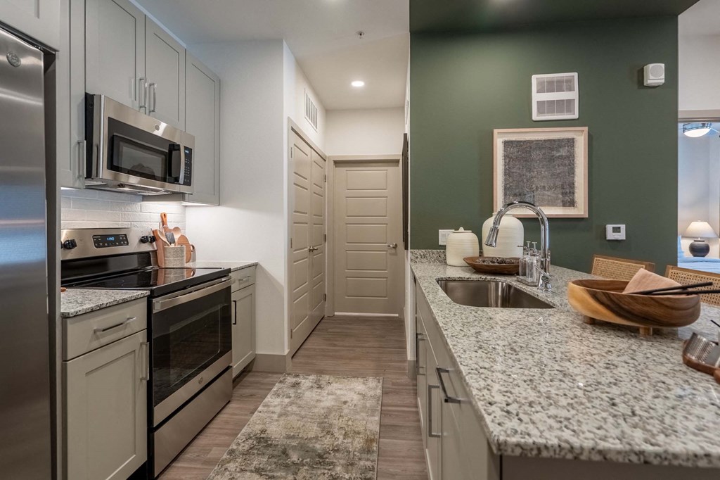 a kitchen with granite counter tops and stainless steel appliances