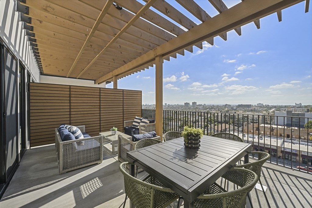 a patio with a wooden table and chairs on a roof