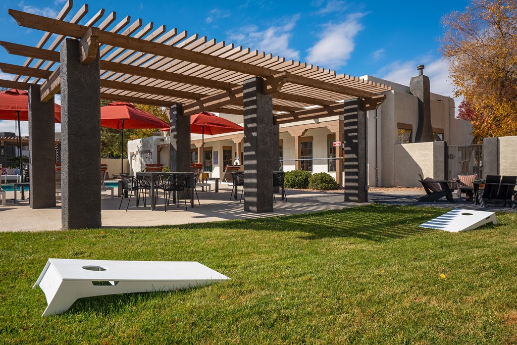 a patio with a pergola and tables with umbrellas