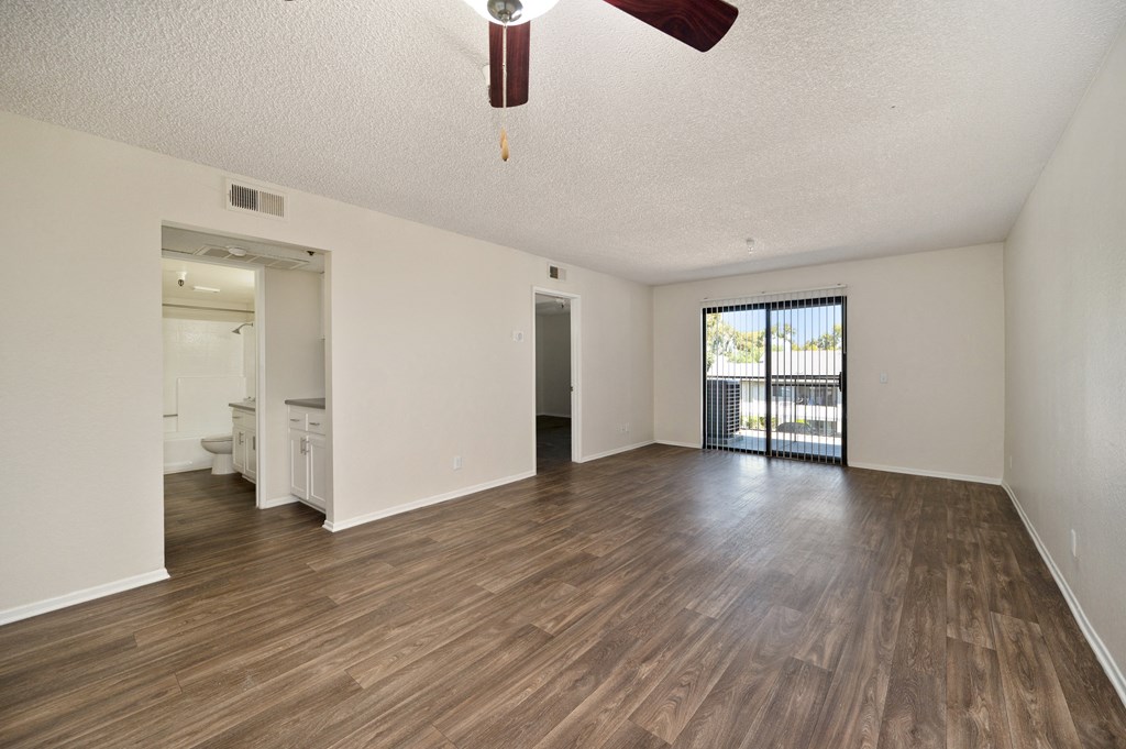 a 2-bedroom apartment living and room with wood floors and a ceiling fan