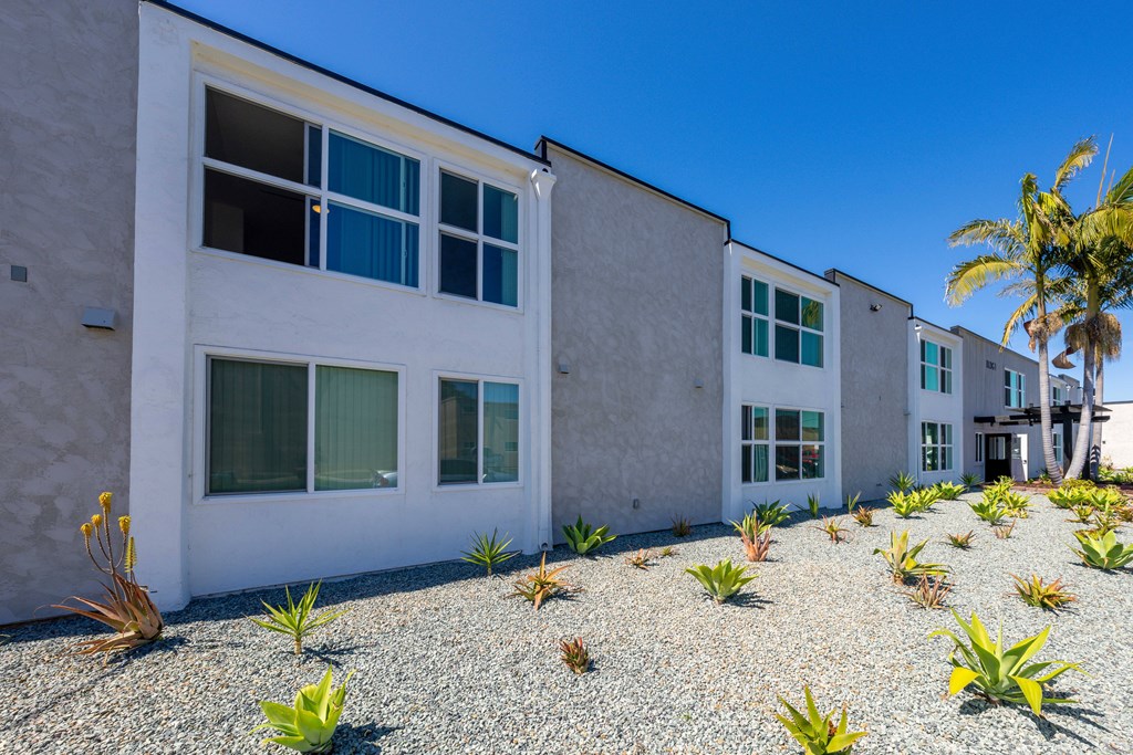 A white building with a gravel area in front of it.