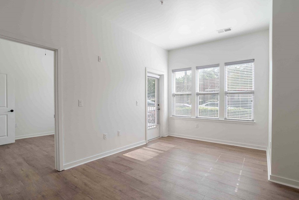 an empty living room with white walls and wood floors