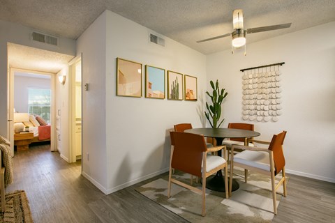 a dining area with a table and chairs and a ceiling fan