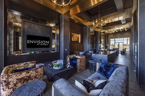 A modern living room with a large couch and a television displaying the word "ENVISION".