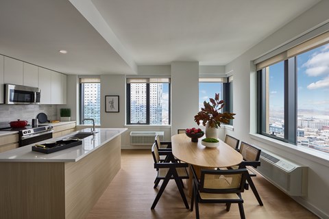 A kitchen with a table and chairs in front of a window.