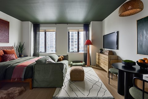 A modern bedroom with a large bed and a TV on the wall.