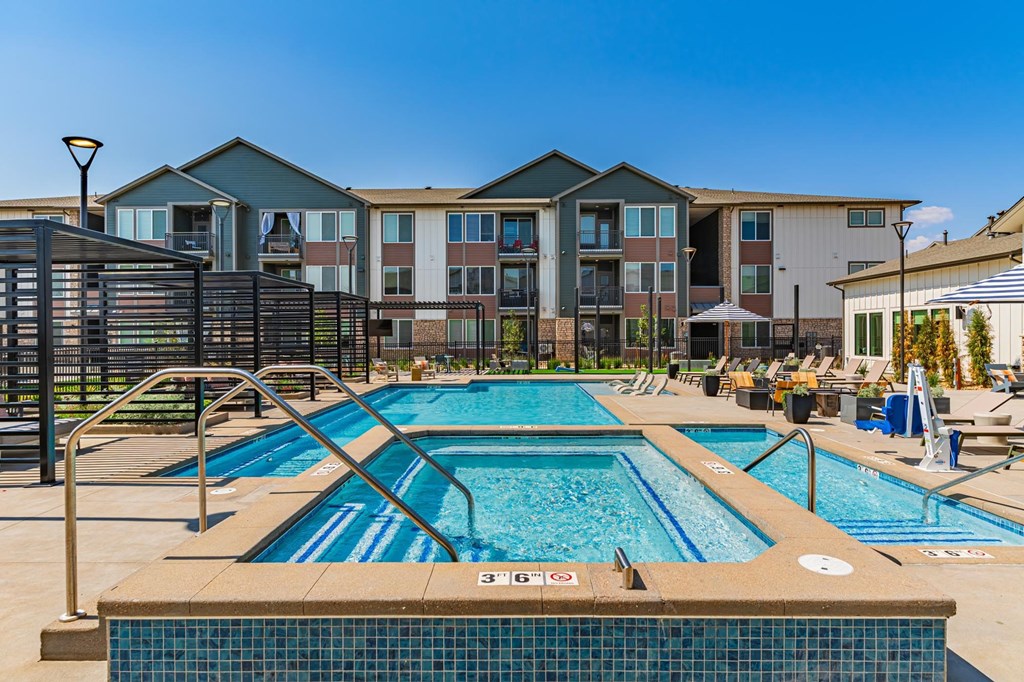 A large swimming pool in front of apartment buildings.