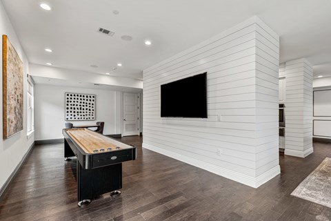 A room with a white wall and a black television.
