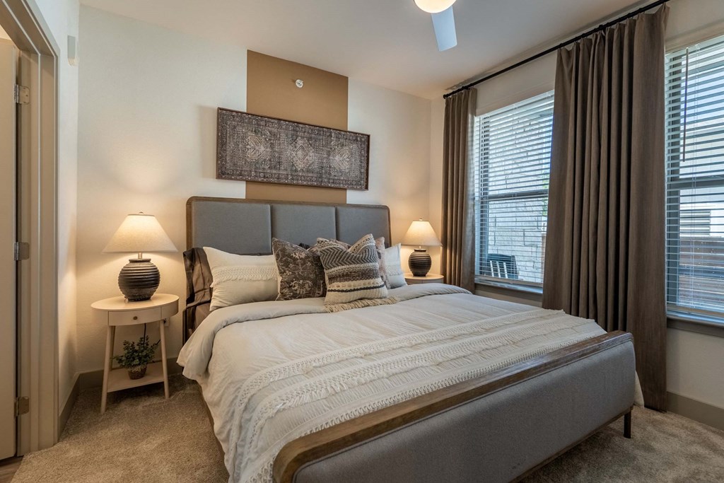 a bedroom with a bed and two windows