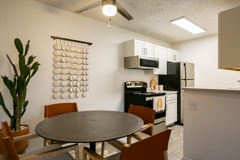 A modern kitchen with a round table and chairs.