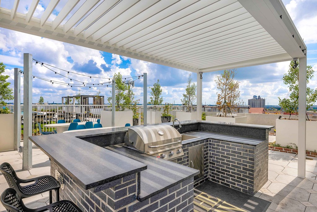 a covered patio with a hot tub and a grill