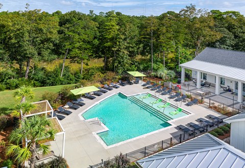 A large swimming pool surrounded by trees and a building.