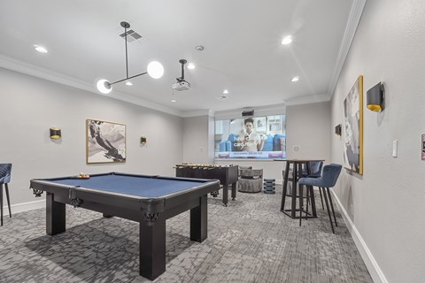 A room with a pool table and a television.