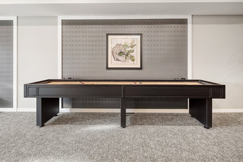 a spacious room with a pool table and a painting on the wall