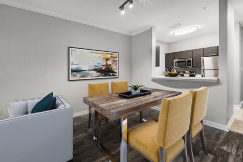 A dining room with a wooden table and yellow chairs.