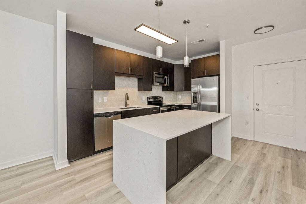 a kitchen with a large island and stainless steel appliances