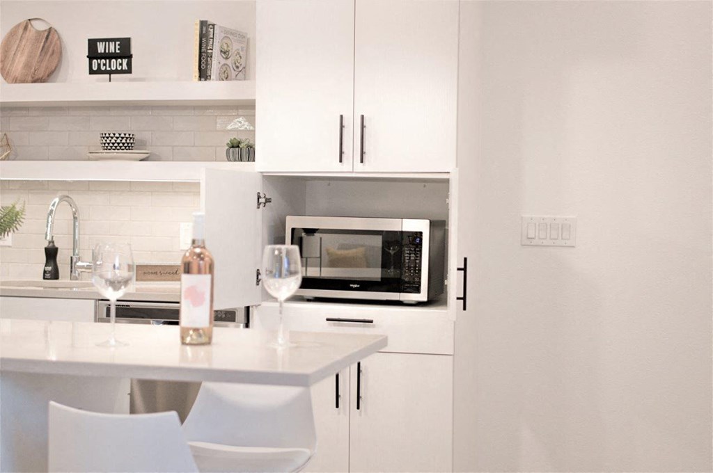a white kitchen with hidden microwave