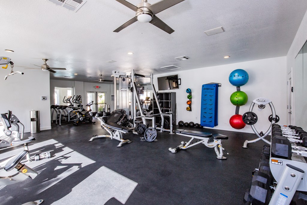 A well-equipped gym with a variety of exercise machines and weights.