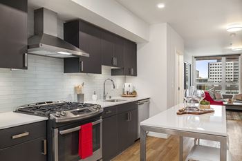 A modern kitchen with a red towel on the stove.