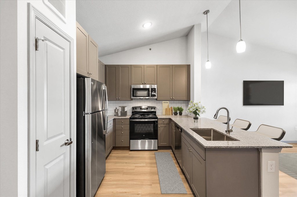 a kitchen with gray cabinets and stainless steel appliances