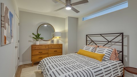 A bedroom with a bed, dresser, and mirror.