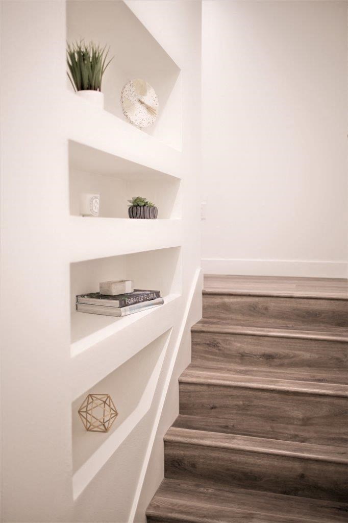 a staircase with white walls and storage