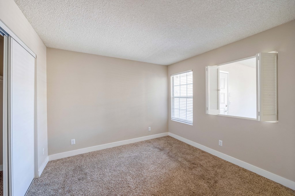 a bedroom with a carpeted floor and a window