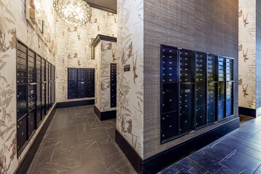 A hallway with a chandelier and a wall with a floral pattern.