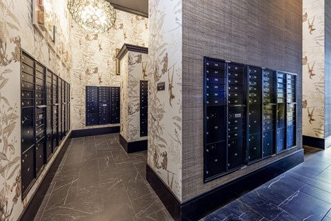 A hallway with a chandelier and a wall with a floral pattern.