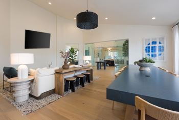 A modern dining room with a long table and chairs.