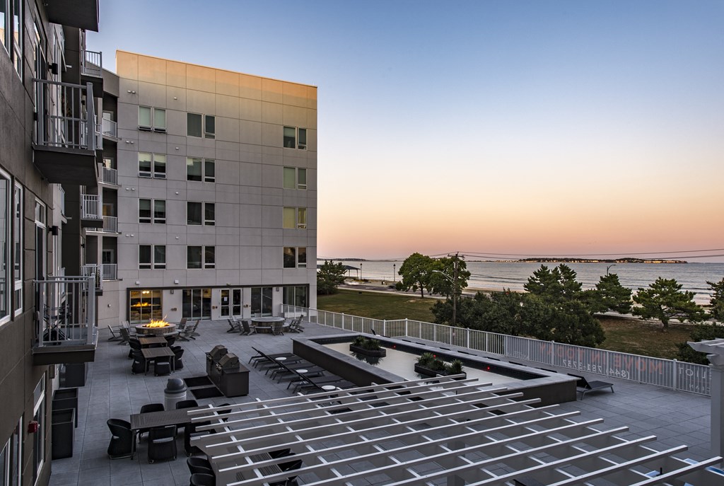 a view of the courtyard of a building overlooking the ocean at sunset