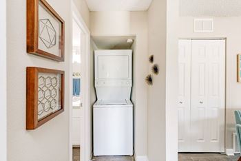 A white washing machine is in a small laundry room.