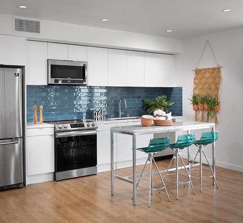 a kitchen with white cabinets and a table with three chairs
