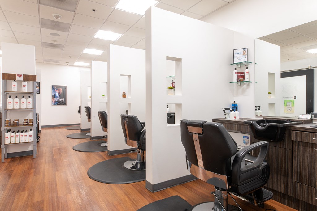 a salon with white walls and wood flooring