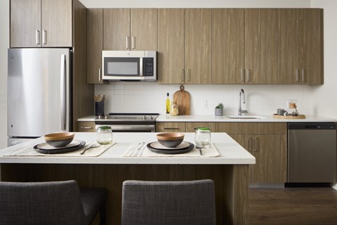 A modern kitchen with a table set for two.