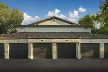 A building with a grey roof and black garage doors.
